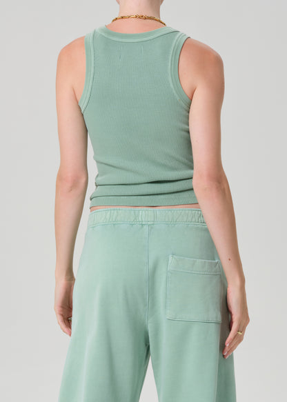 Person wearing a matching mint green tank top and pants against a light gray background
