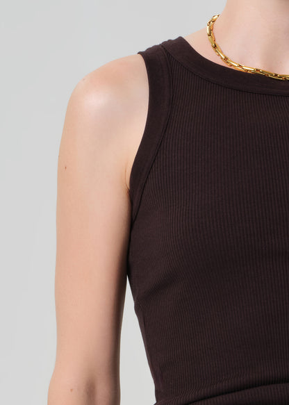 Person wearing a brown ribbed tank top with brown pants
