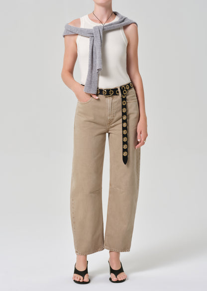 Person wearing a sleeveless top, beige pants with a belt, and a gray scarf on a white background