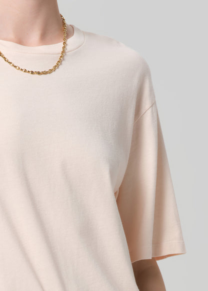 Person wearing a light pink t-shirt and pants on a plain background