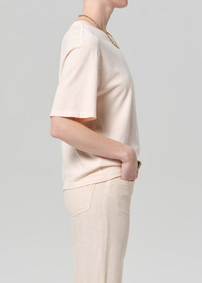 Person wearing a light pink t-shirt and pants on a plain background
