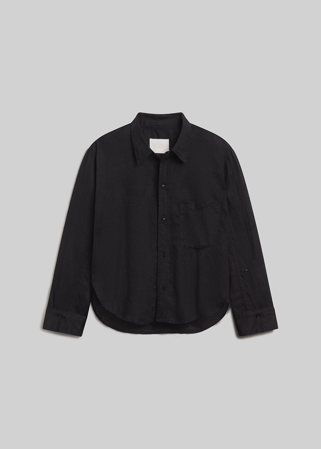 Black long-sleeve button-front linen shirt with chest pocket on grey background