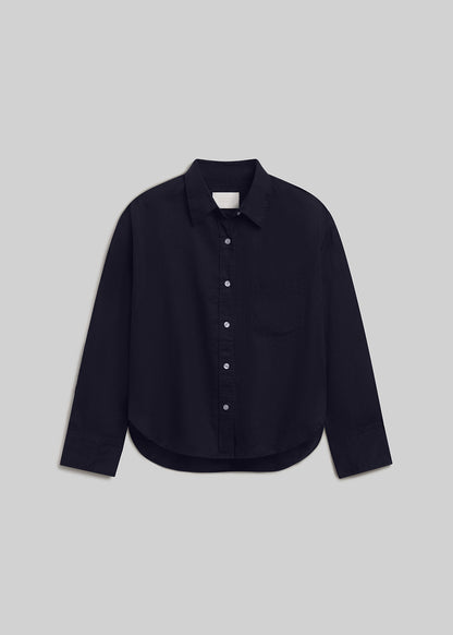 True navy long-sleeve linen button-down shirt with a pointed collar, front button closure, single chest pocket, buttoned cuffs, and curved hem, front flat lay view on a grey background.