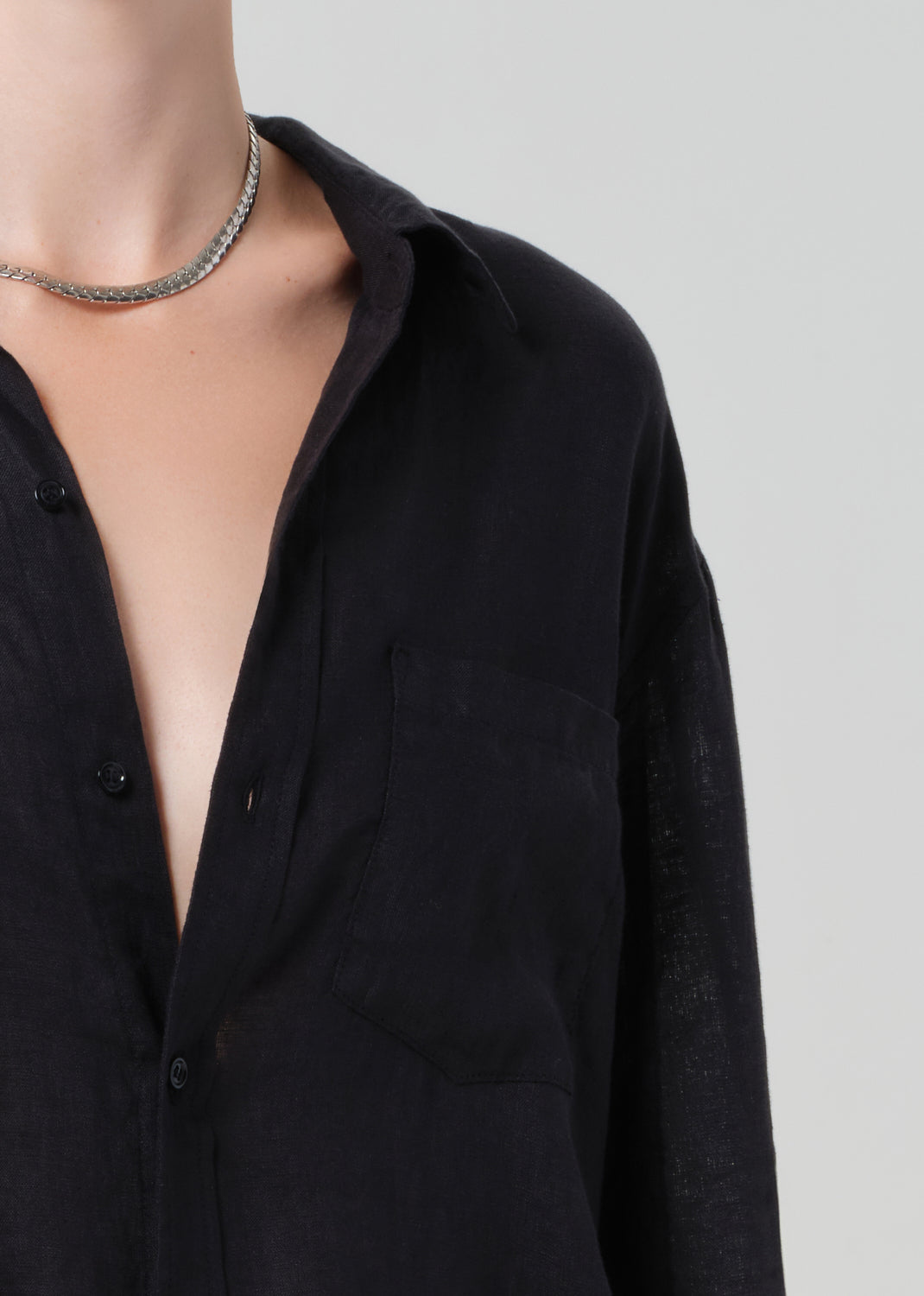 Black shirt with a deep neckline on a plain background