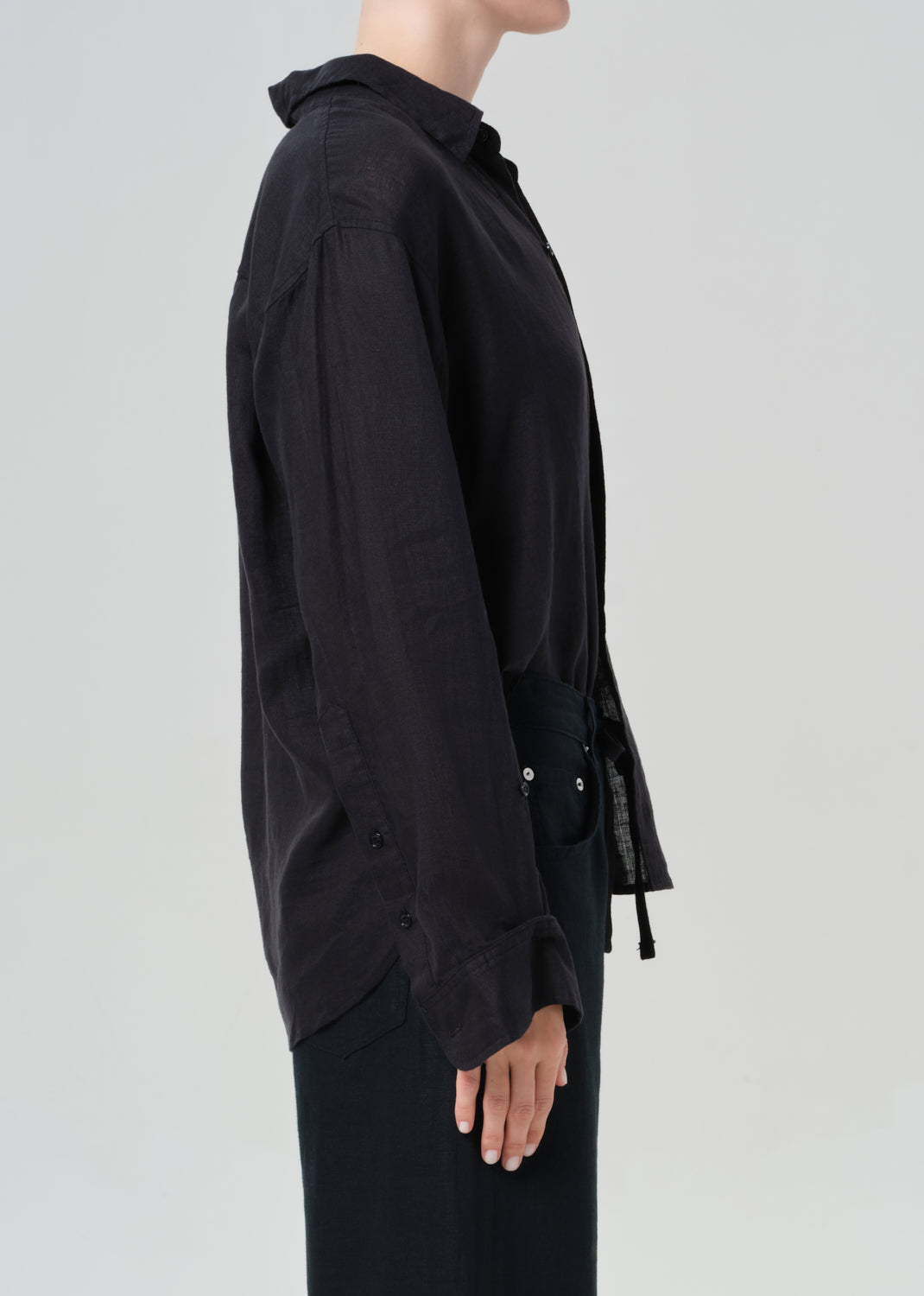 Black shirt worn by a person on a light gray background