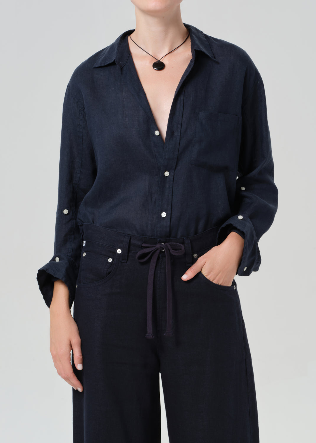 Person wearing a navy linen set with a plain background