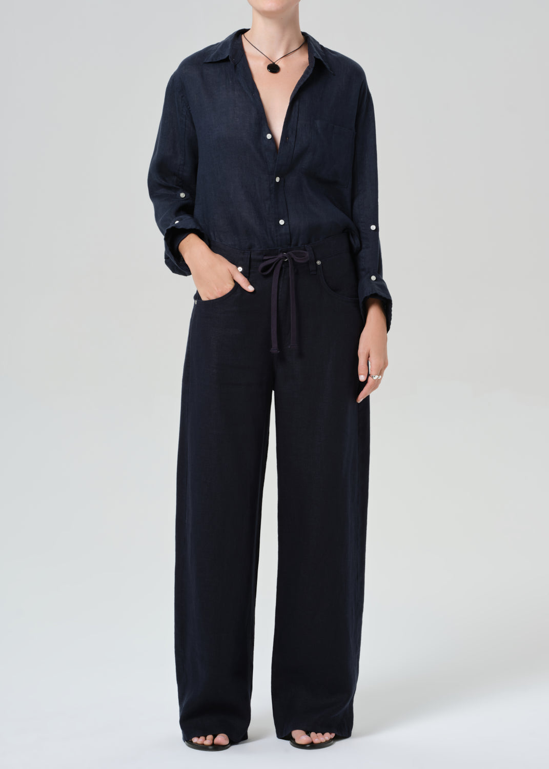 Person wearing a navy linen set with a plain background