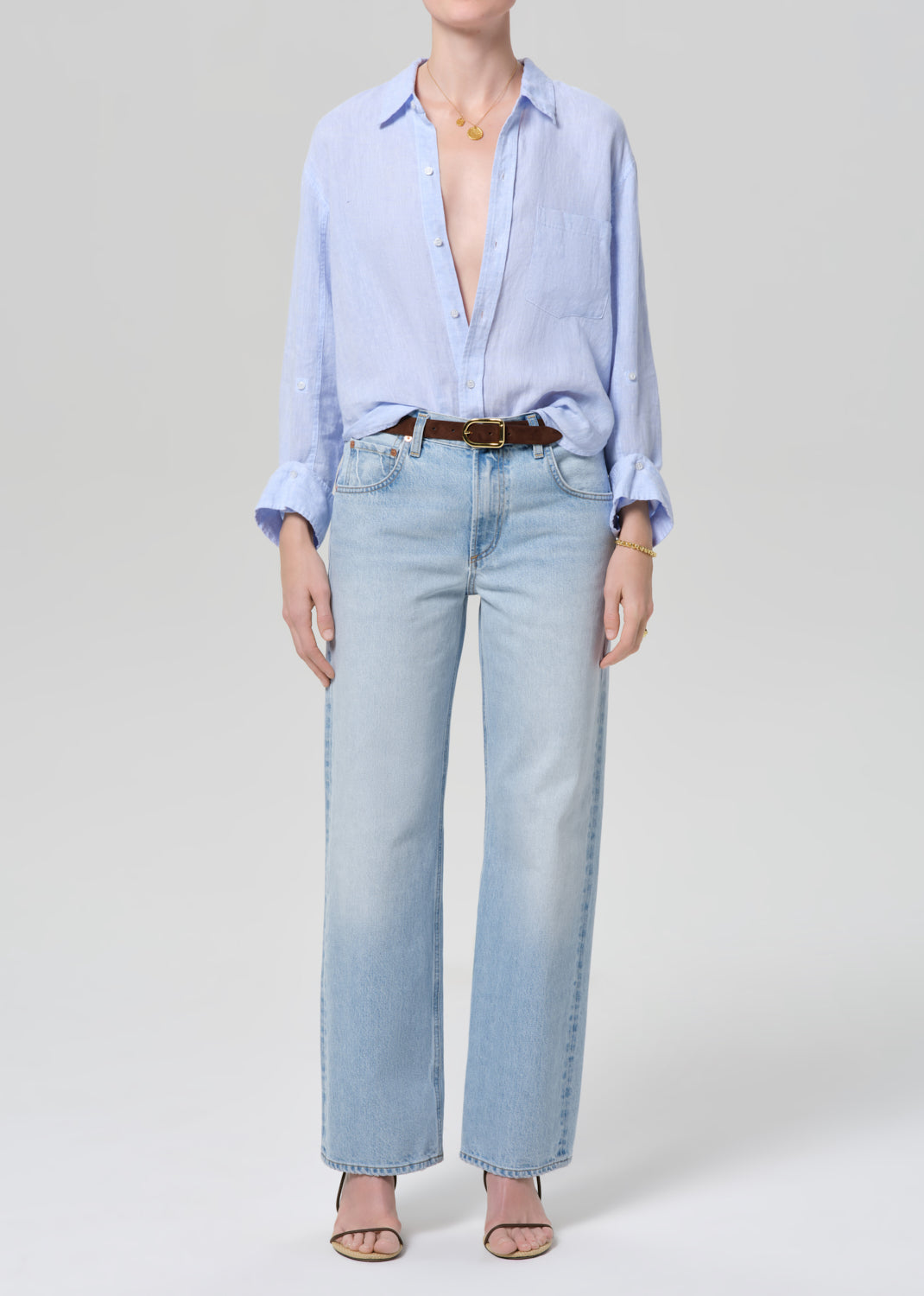 Person wearing a light blue shirt and jeans on a white background