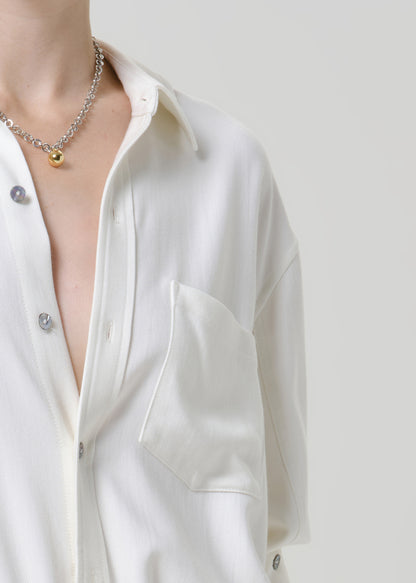 Close-up of a white button-up shirt on a grey background.