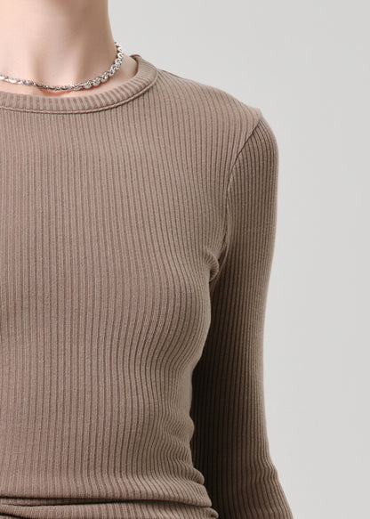 Brown ribbed sweater worn by a person on a grey background