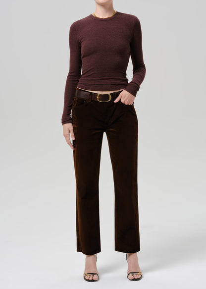 A model wearing a dark brown long-sleeve knit top and matching dark brown wide-leg trousers with a brown belt, shown against a grey background.