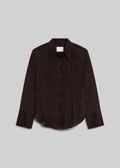 Brown long-sleeve button-down shirt with a pointed collar, front button closure, wide cuffs, and curved hem, front flat lay view on a grey background.