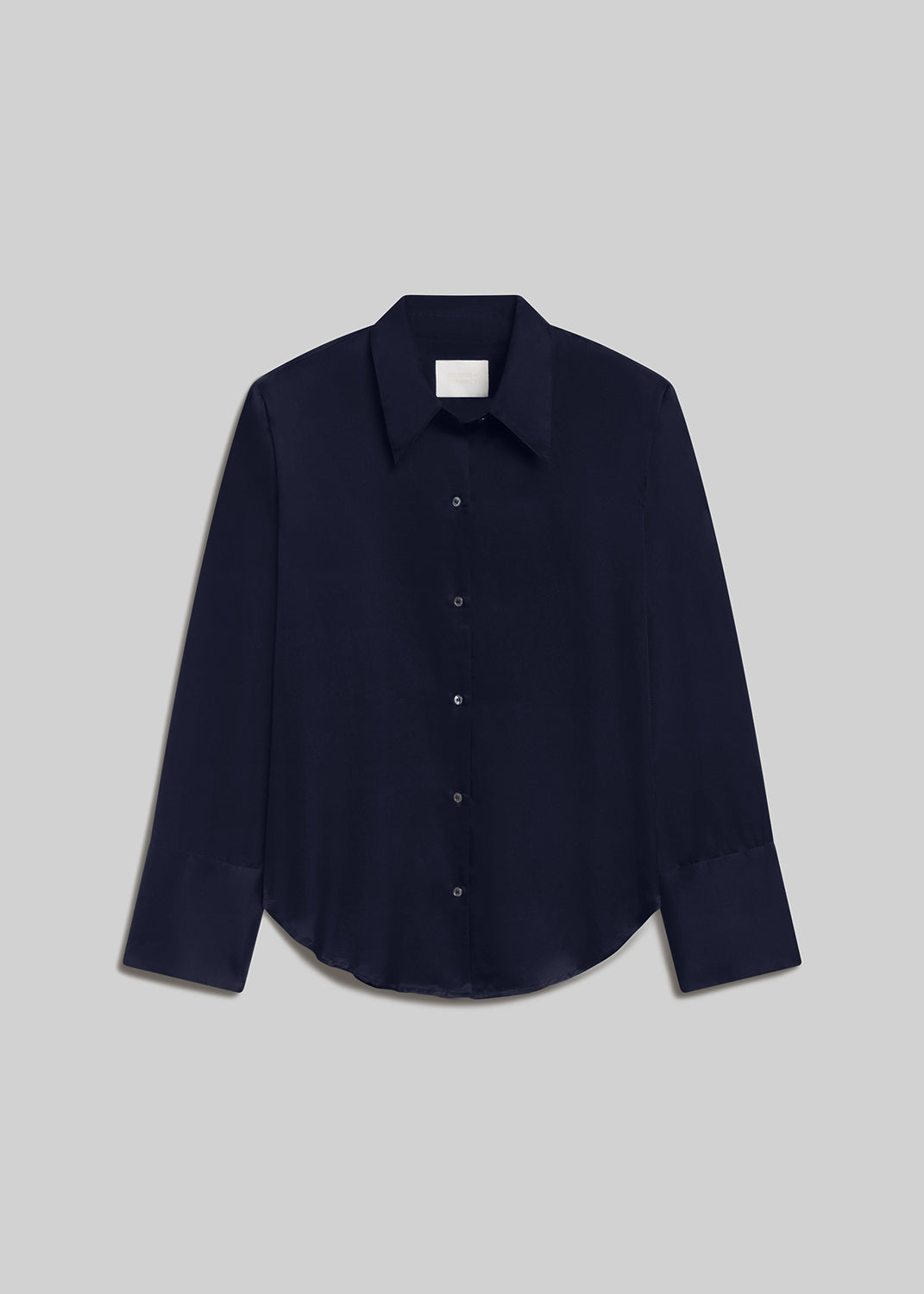 Midnight navy long-sleeve button-down shirt with a pointed collar, front button closure, wide cuffs, and curved hem, front flat lay view on a grey background.