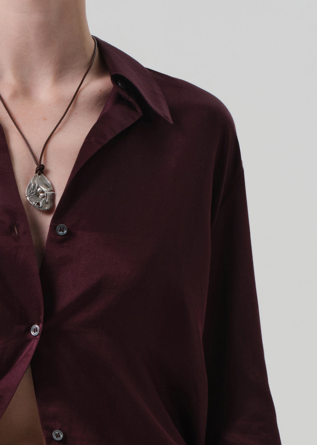 Burgundy shirt worn by a person on a plain background