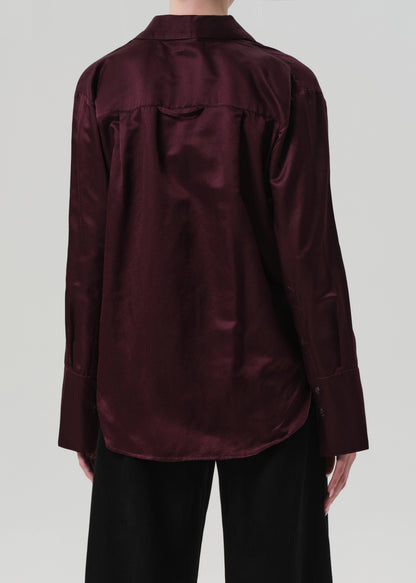 Burgundy shirt worn by a person on a plain background
