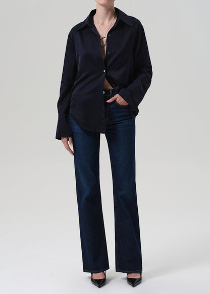 Person wearing a navy shirt and dark blue jeans on a white background