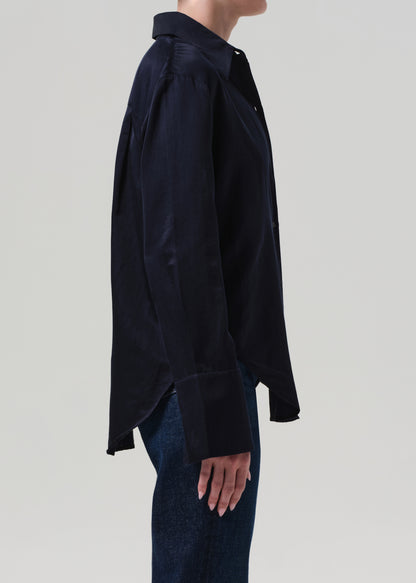 Person wearing a navy shirt and blue jeans on a light gray background