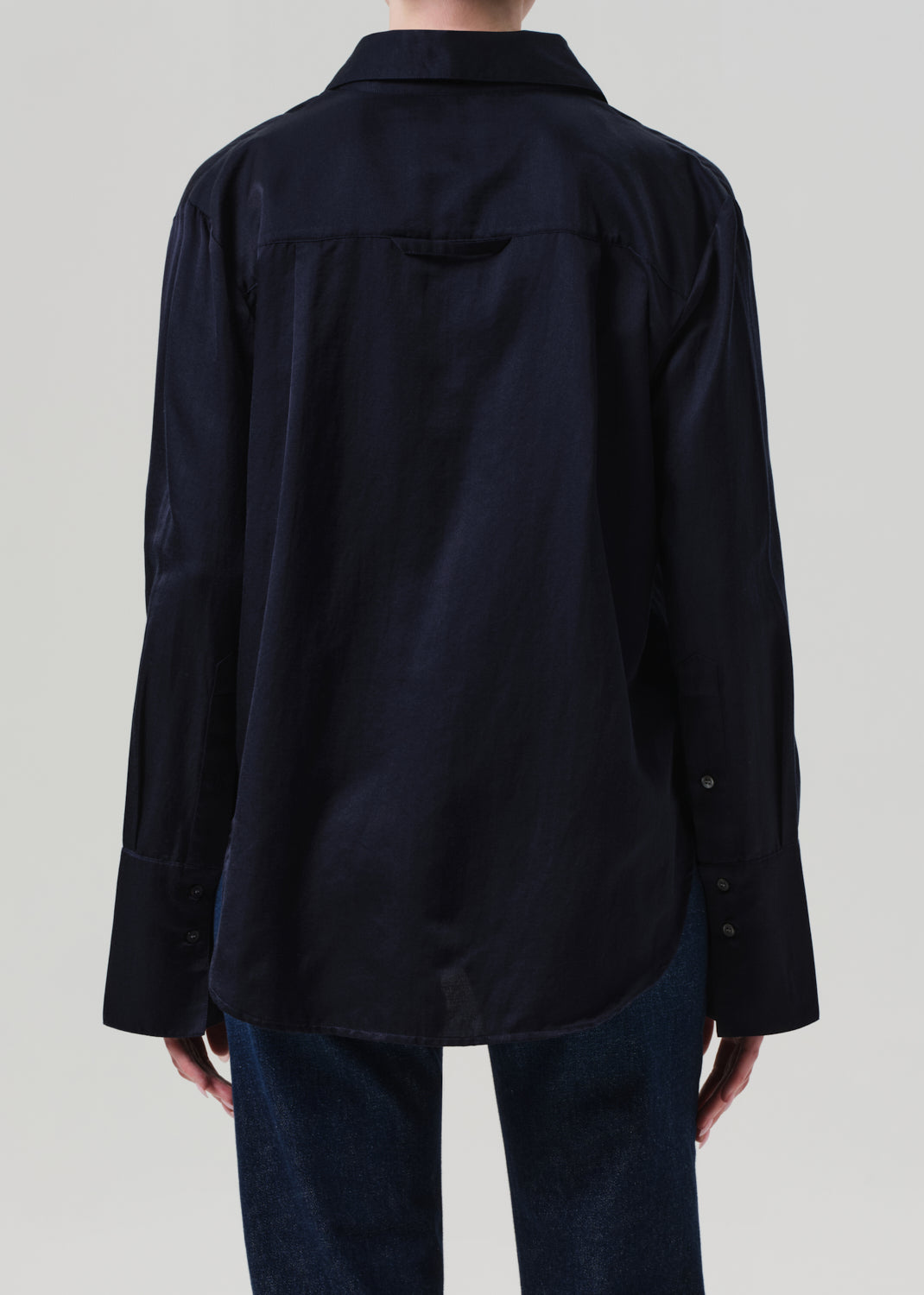 navy shirt worn by a person on a plain background