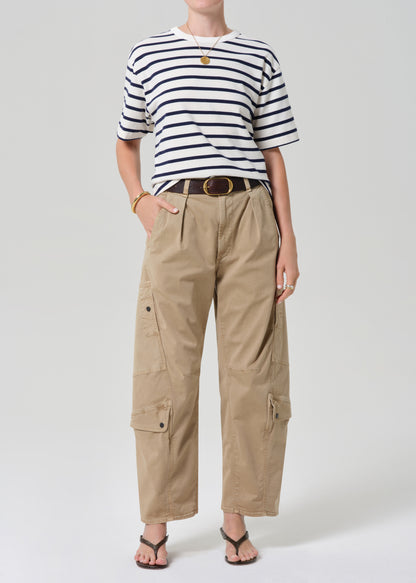 Person wearing a striped shirt and beige cargo pants on a grey background