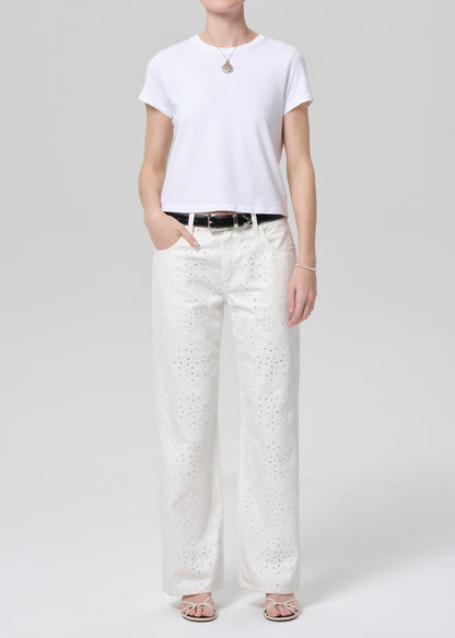 Person wearing a white t-shirt and white pants on a plain background