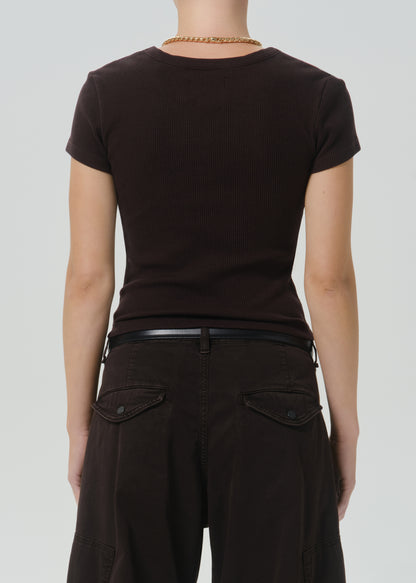 Rear view of a person wearing a fitted short-sleeve dark brown t-shirt and dark brown pants with a thin black belt, against a grey background.