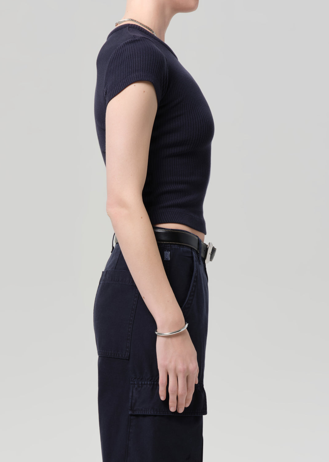 Person wearing a navy ribbed tee and navy cargo pants on a light gray background