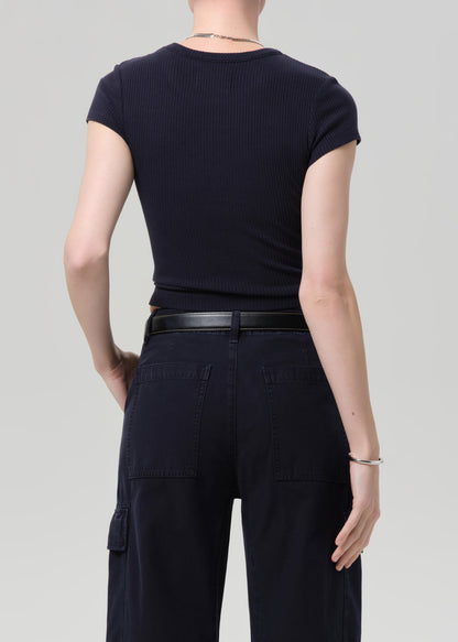 Person wearing a navy ribbed tee and navy cargo pants on a light gray background