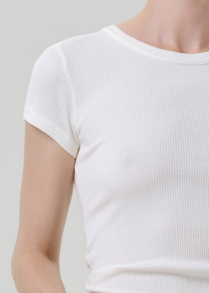 Close-up of a person wearing a white short-sleeve ribbed knit top against a grey background.
