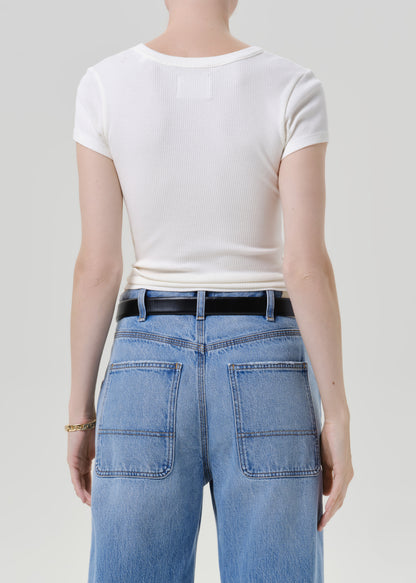 Rear view of a model wearing a white short-sleeve crewneck t-shirt tucked into light blue jeans with a black belt, against a grey background.