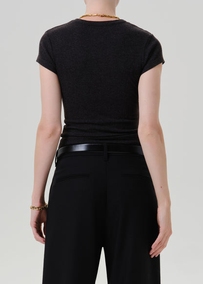 Person wearing a black ribbed cap sleeve tee with black wide leg trousers viewed from the back on a grey background