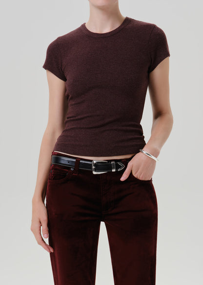 A model wearing a short-sleeve crewneck knit top in a deep burgundy color, paired with burgundy pants and a black belt, against a grey background.
