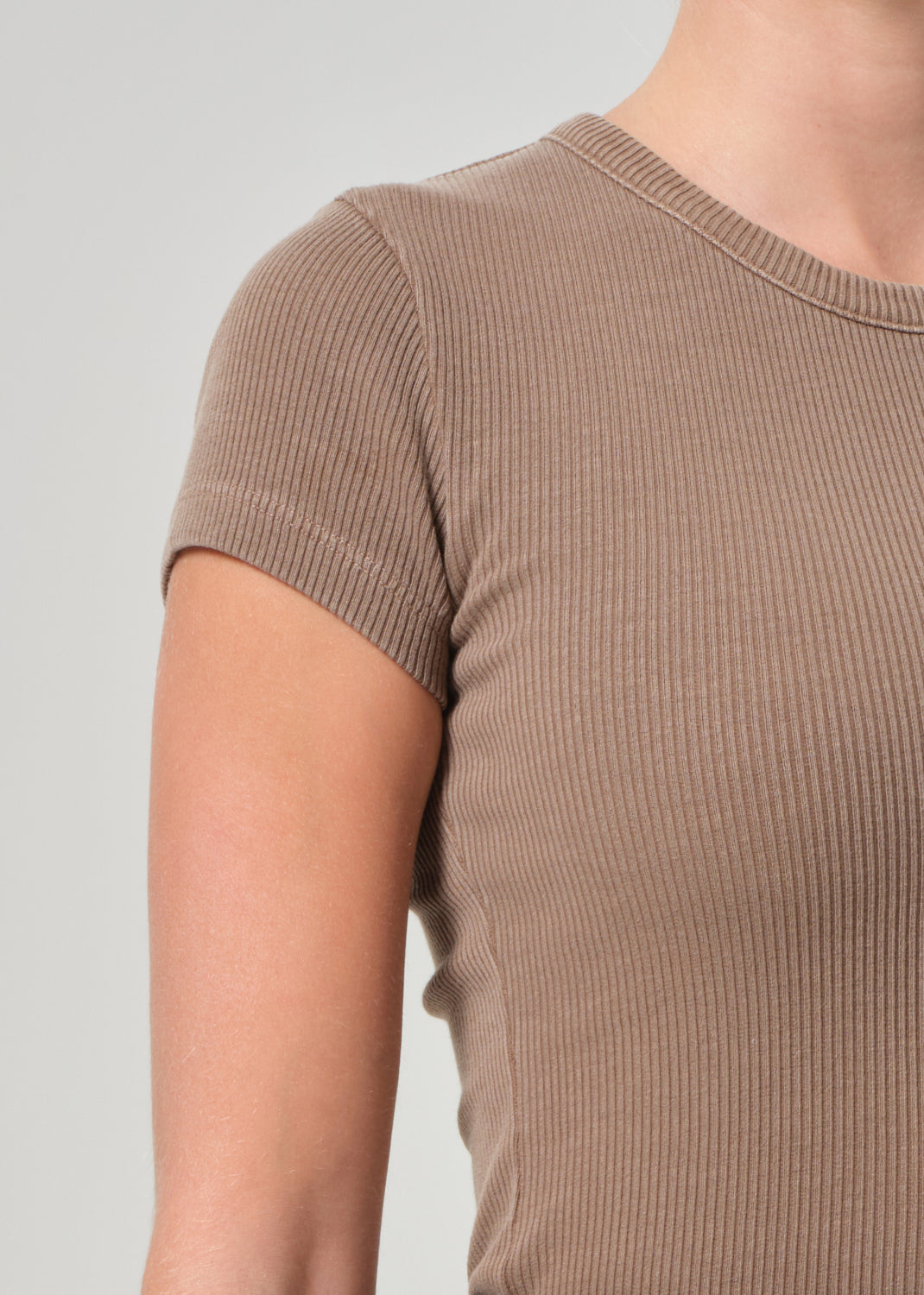 Brown ribbed t-shirt worn by a person on a plain background