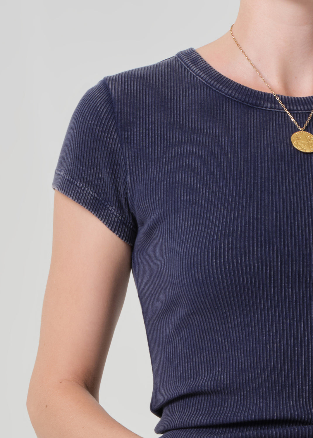 Navy ribbed knit top worn by a person on a light gray background