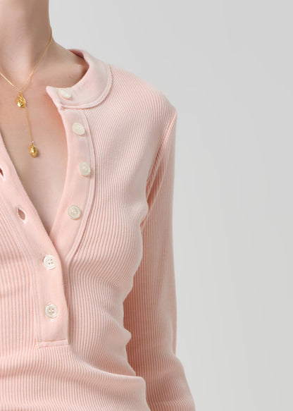 Person wearing a light pink long-sleeve shirt