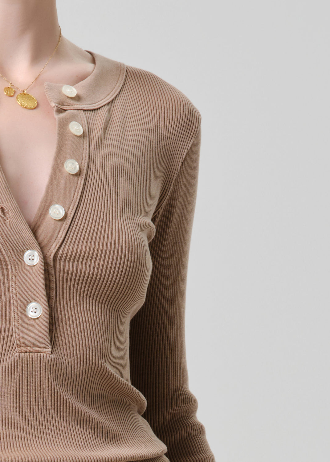 Brown ribbed cardigan with button details on a grey background