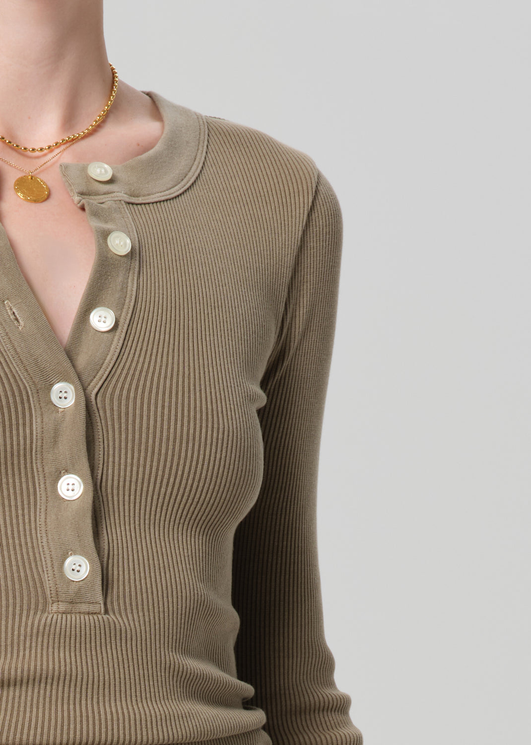 Brown ribbed top with buttons on a plain background
