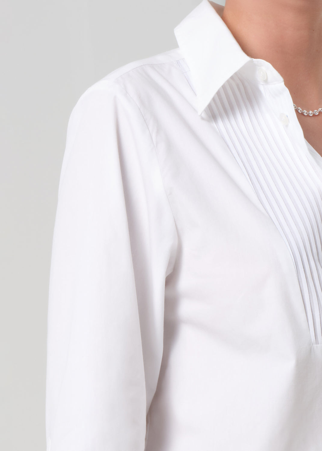 Close-up of a white blouse with a collar on a light gray background