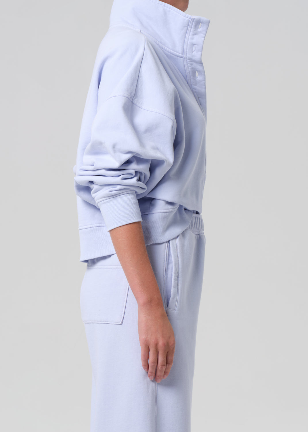 Light blue tracksuit worn by a person on a light gray background