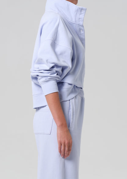 Light blue tracksuit worn by a person on a light gray background