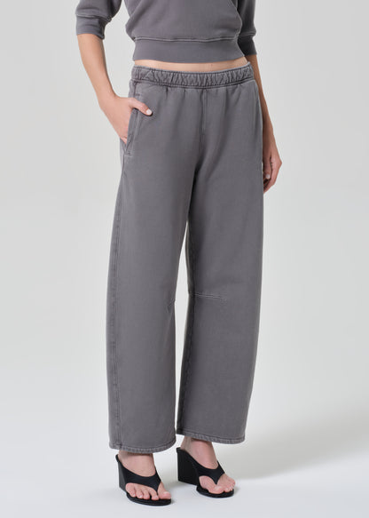 Person wearing a gray top with matching grey sweatpants on a grey background