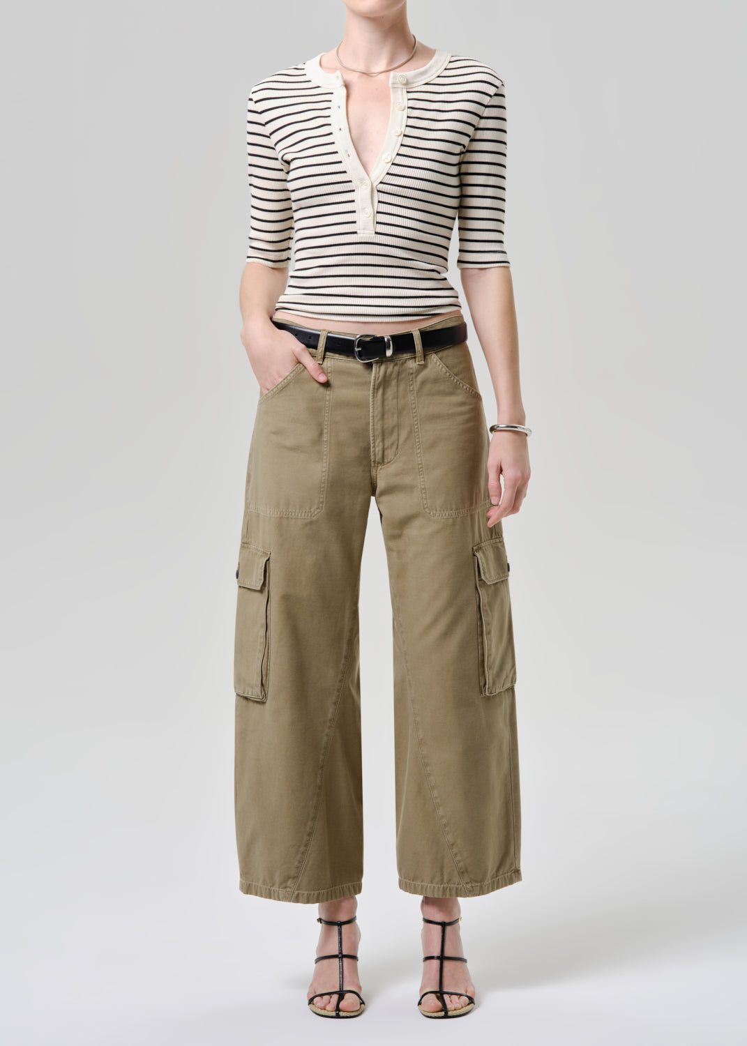 Person wearing a striped shirt and cargo pants on a white background