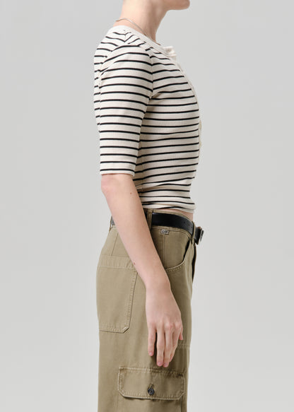 Person wearing a striped shirt and cargo pants on a plain background