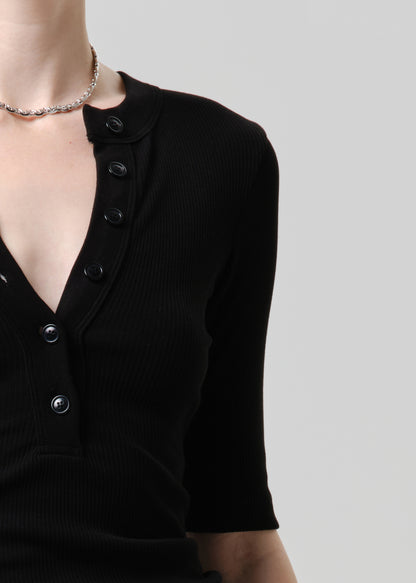 Black cardigan with button details on a neutral background