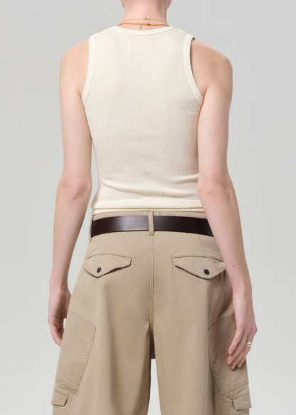 Person wearing a beige sleeveless top and beige cargo pants on a light gray background