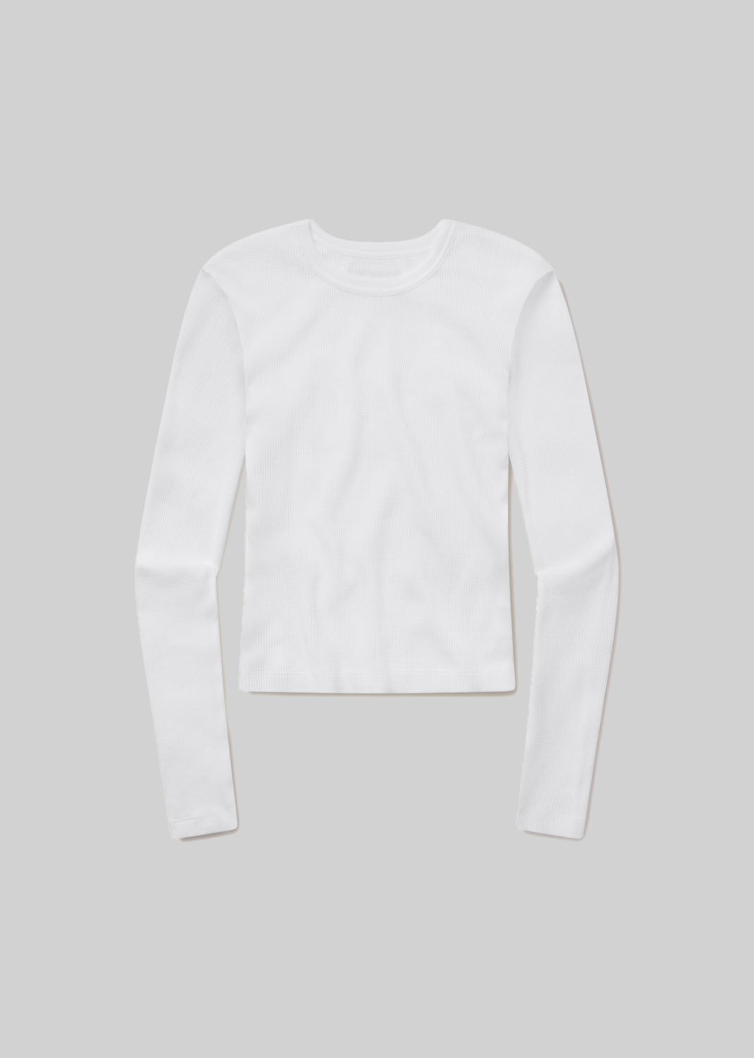 White long-sleeve ribbed crewneck top with a fitted silhouette and straight hem, front flat lay view on a grey background.