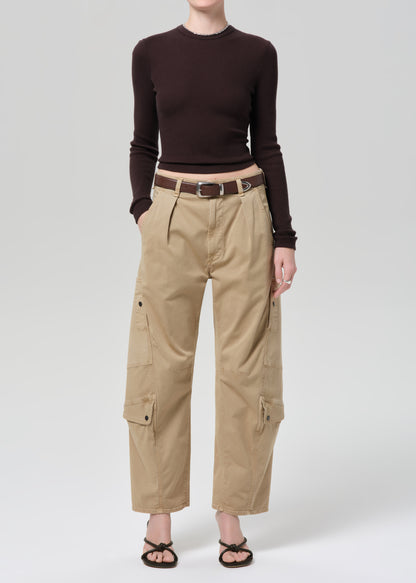 Person wearing a brown long-sleeve top and beige cargo pants on a white background