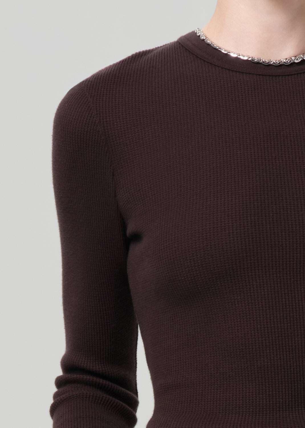 Brown ribbed sweater on a gray background