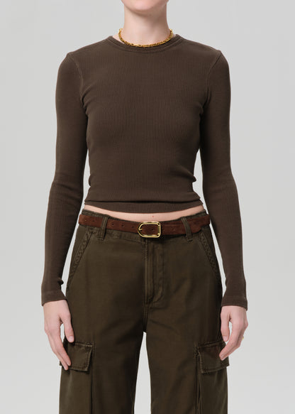 Person wearing a brown long-sleeve top and cargo pants on a plain background