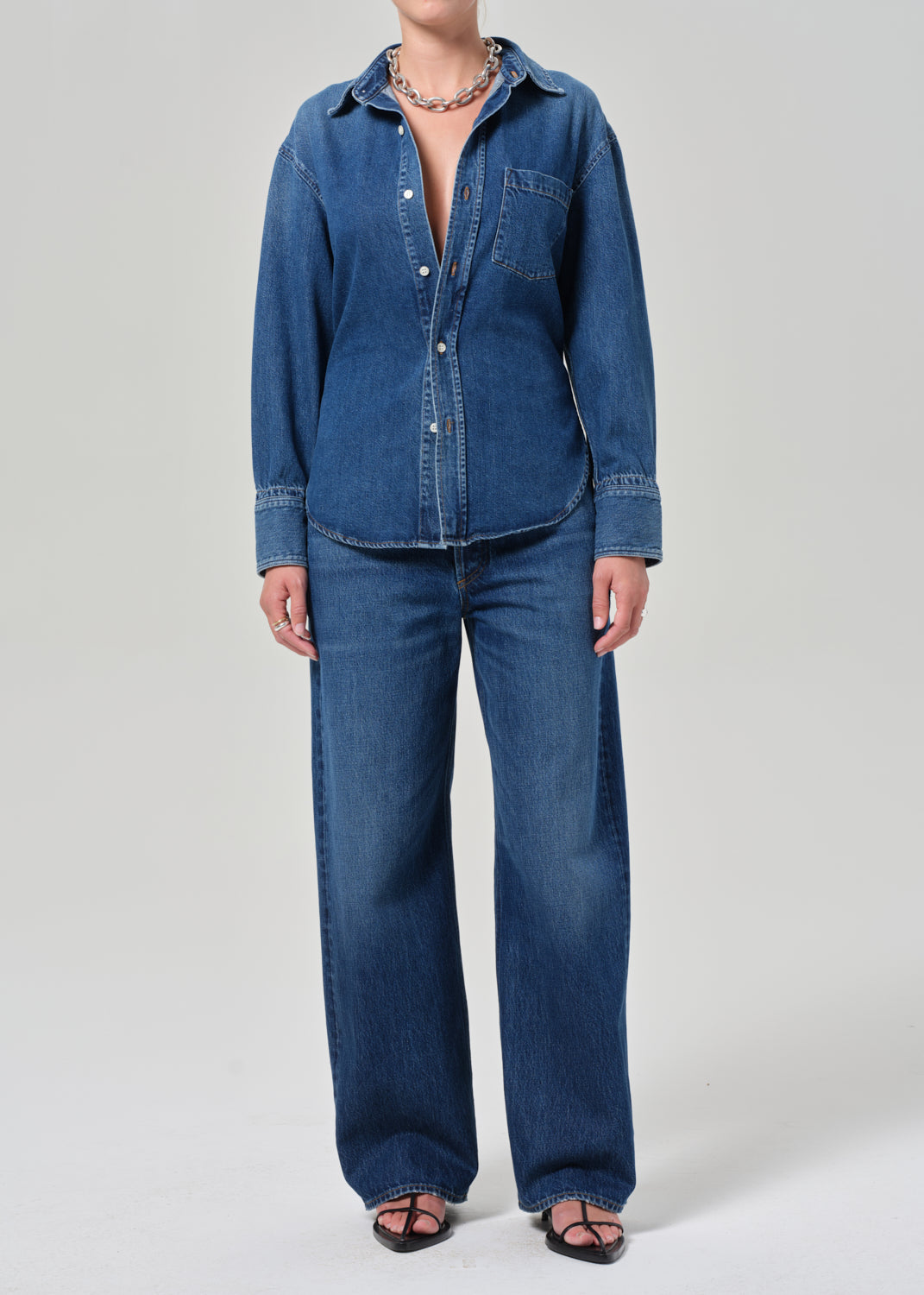 Person wearing a blue denim outfit on a plain background