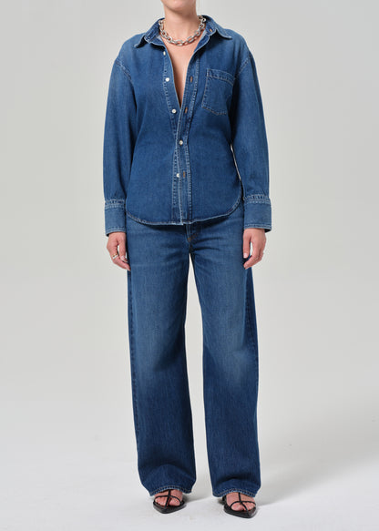 Person wearing a blue denim outfit on a plain background